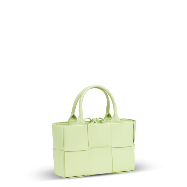 Un petit sac à main en cuir vert clair tressé de la marque Bottega Veneta.