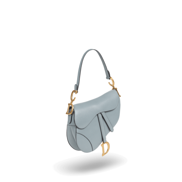 Un sac à main bleu clair avec du matériel doré de la marque Dior.